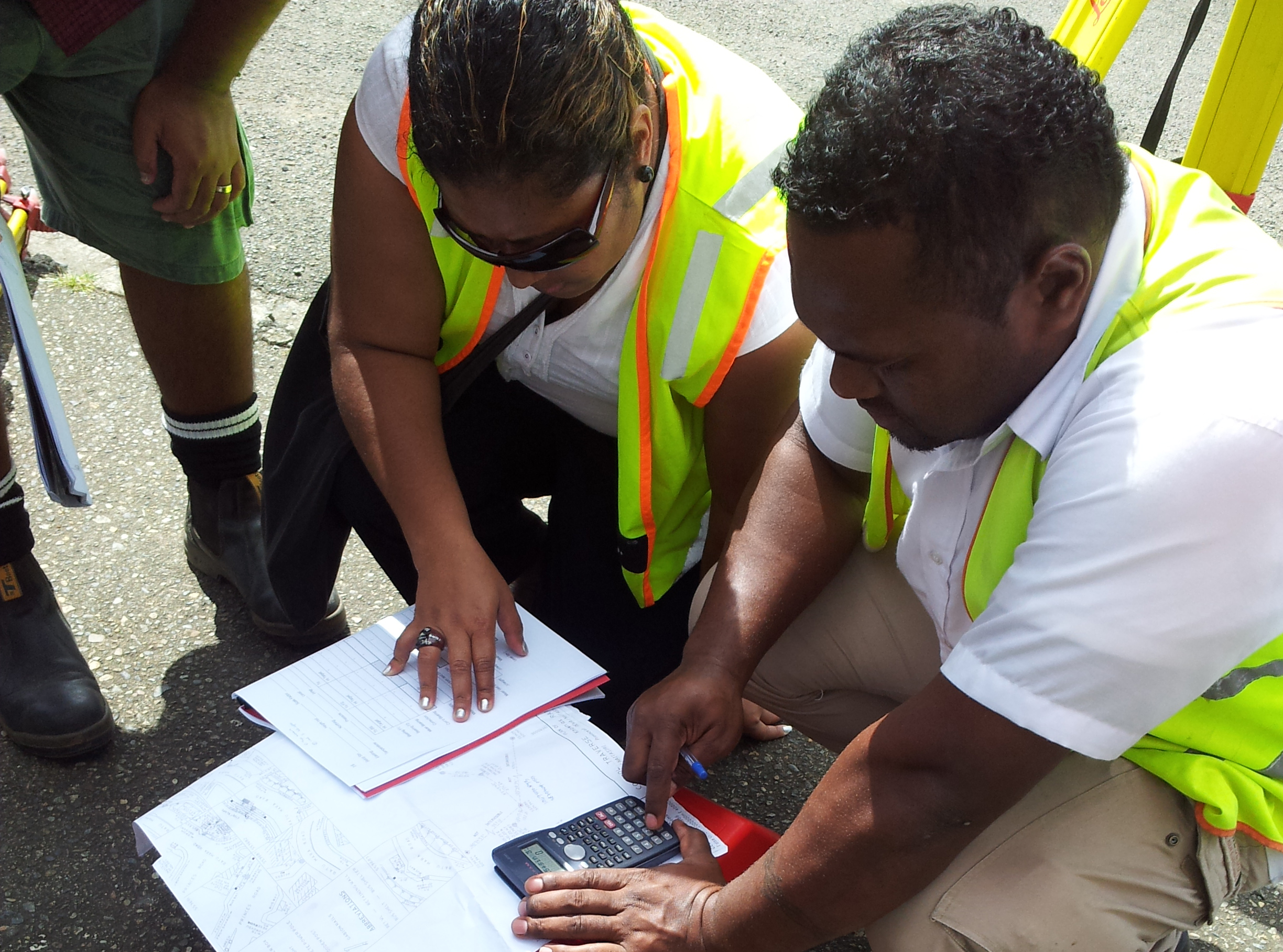 Survey staff reviewing field calculations during practical training